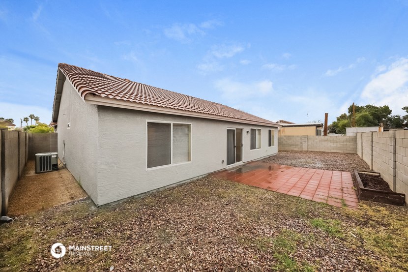 a small white house with a yard and a driveway
