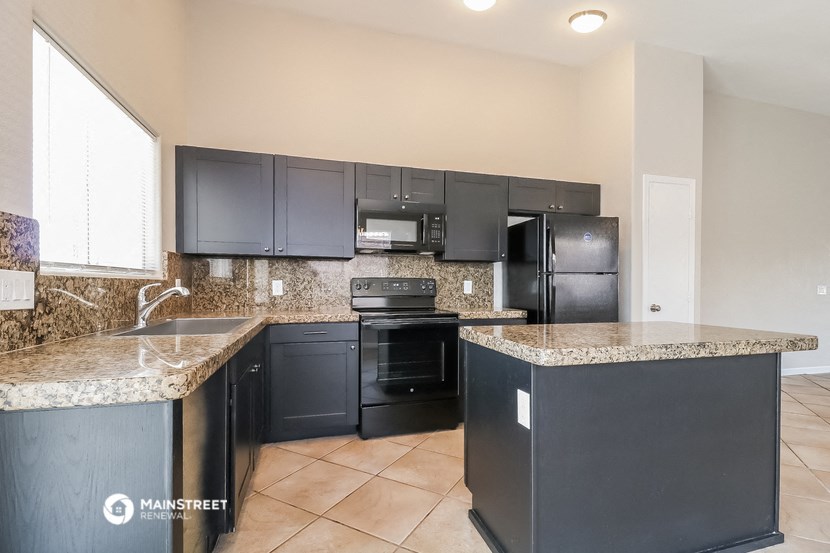 a kitchen with granite counter tops and black appliances