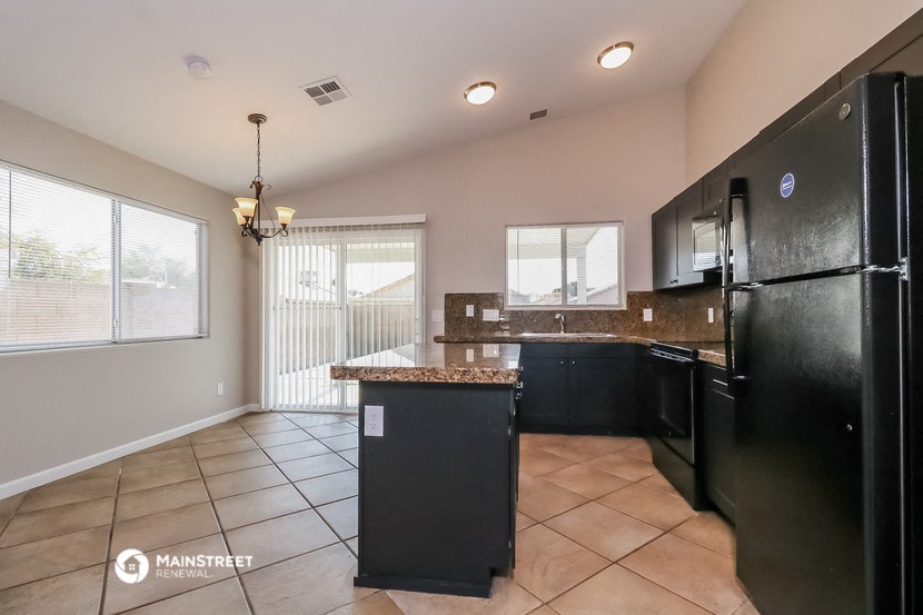 a kitchen with black appliances and tile flooring and a black refrigerator
