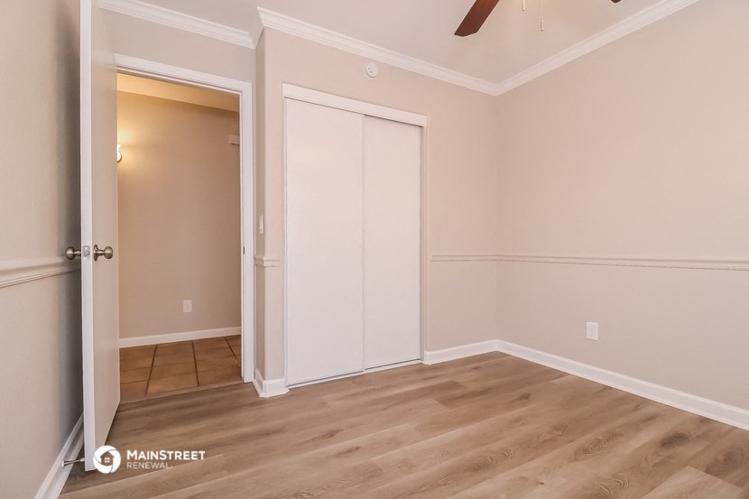 a bedroom with a closet and a door to the bathroom