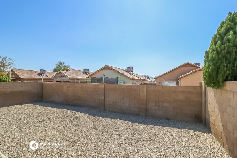 a backyard with a retaining wall and houses in the background