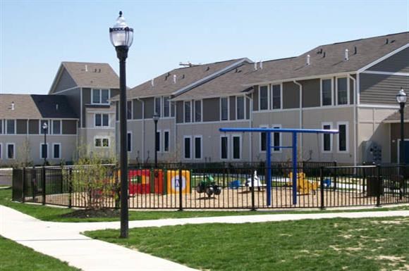 an apartment building with a playground in front of it