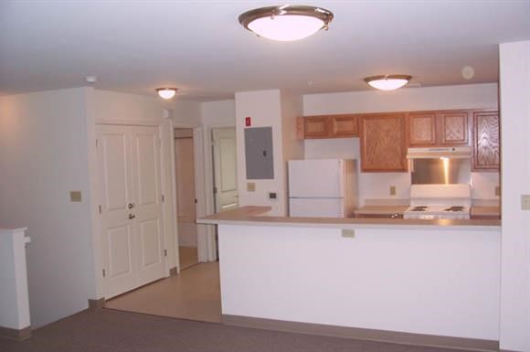 an empty kitchen with a counter and a refrigerator