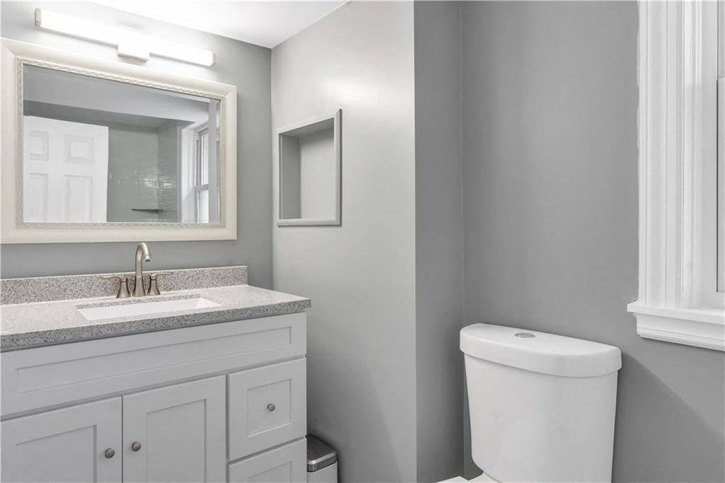 a bathroom with a toilet and a sink and a mirror