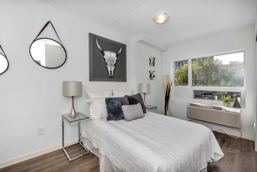 a bedroom with a bed and a large window