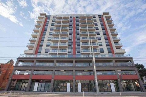 a tall building with many balconies and a cloudy sky