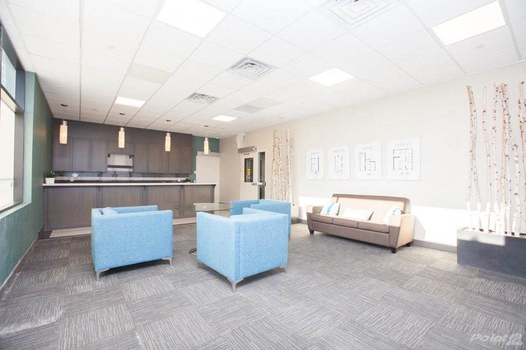 a large room with couches and chairs and a kitchen