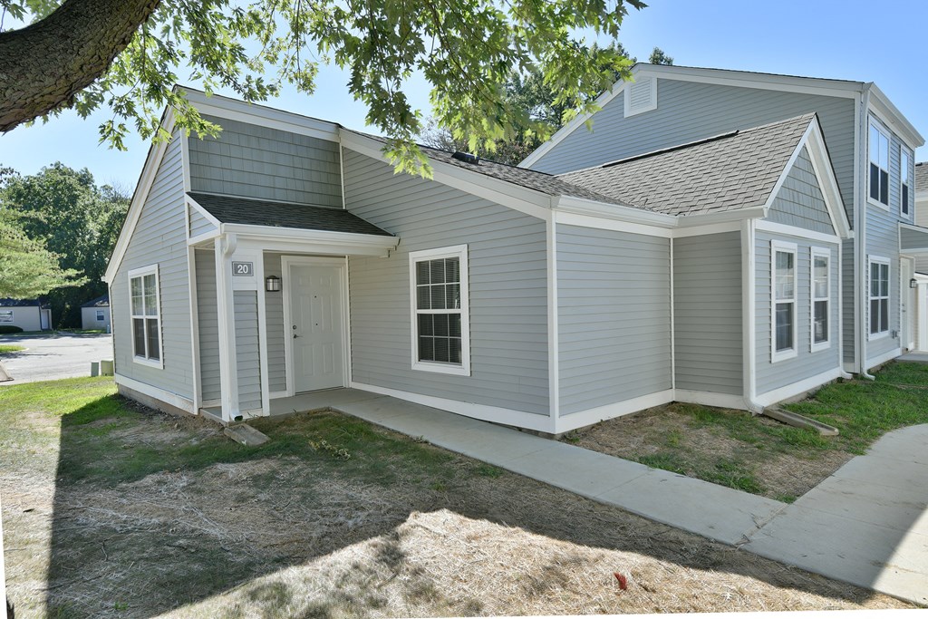 a gray house with a sidewalk in front of it