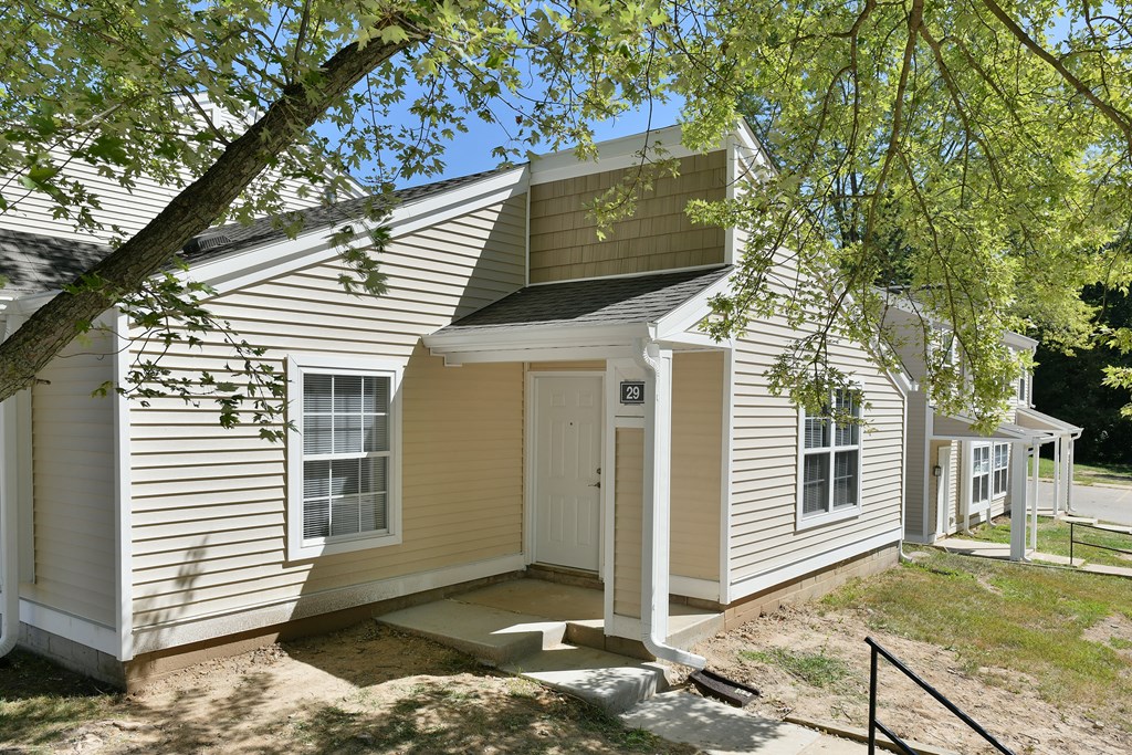 a small white house with a tree next to it