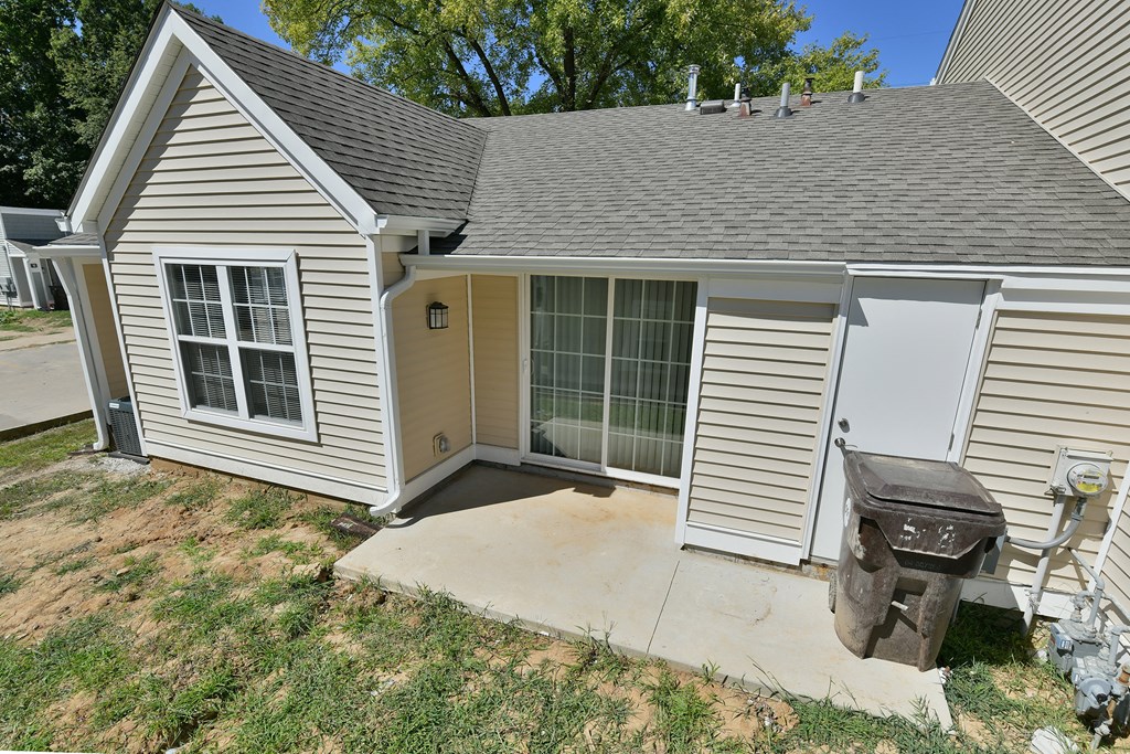 the front of a house with a patio and a backdoor