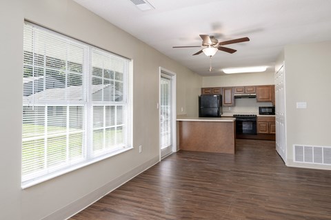 an empty kitchen with a large window and a ceiling fan