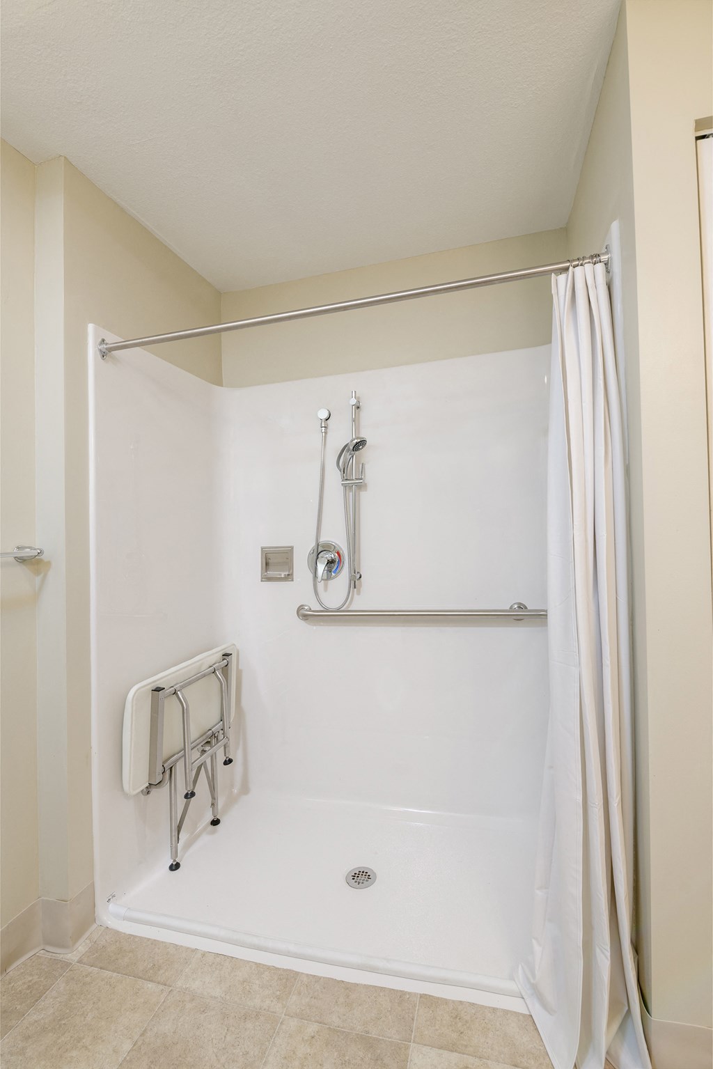 a bathroom with a shower and a towel rack and a shower curtain