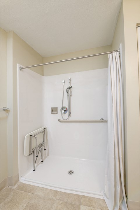 a bathroom with a shower and a towel rack and a shower curtain