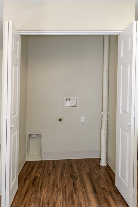 a room with white walls and a wood floor and a white door