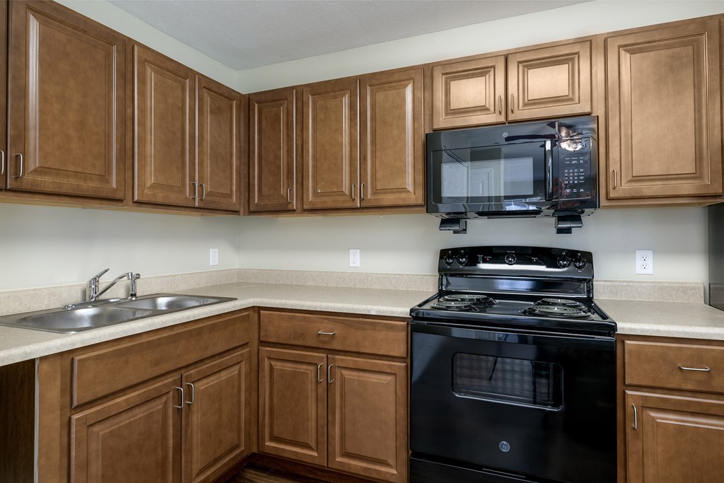 a kitchen with black appliances and wooden cabinets