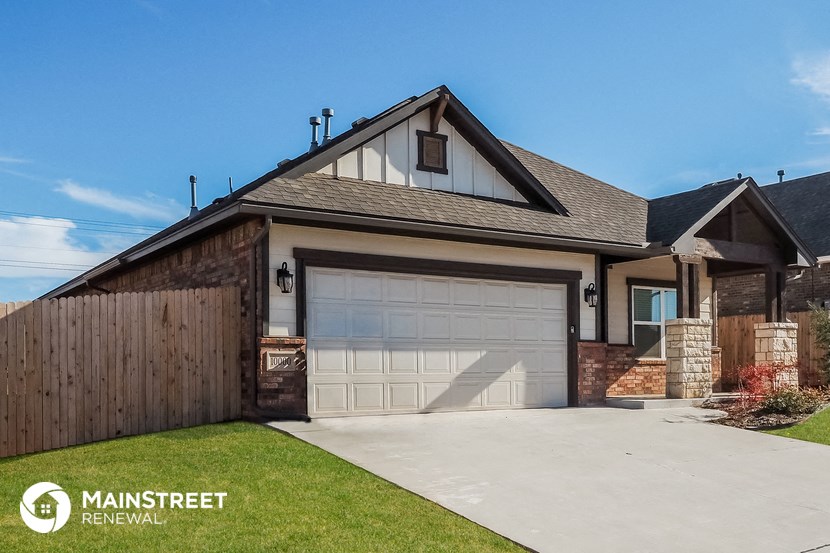a detached garage with a white garage door in front of a house