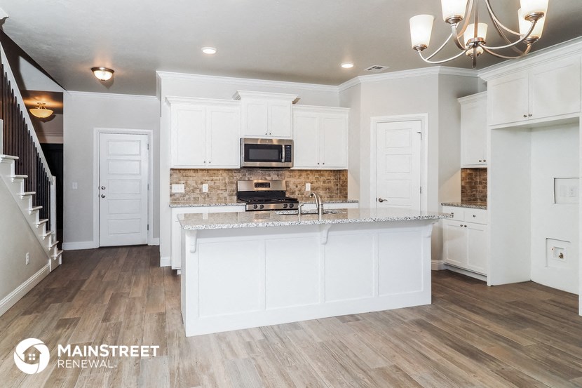 a kitchen with white cabinets and a marble counter top