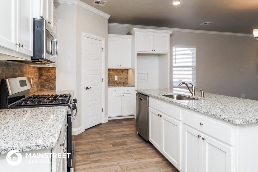 a kitchen with white cabinets and granite counter tops