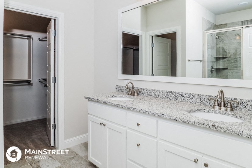 a white bathroom with two sinks and a large mirror
