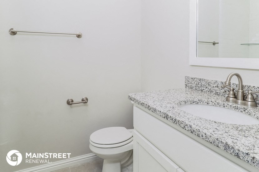 a bathroom with a toilet and a sink and a mirror