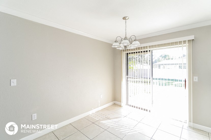an empty living room with a sliding glass door to the pool