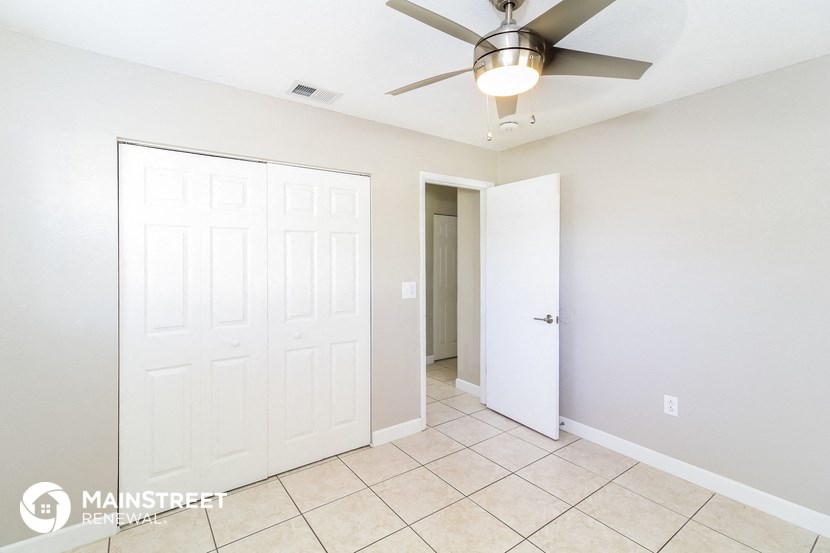 a bedroom with two closets and a ceiling fan