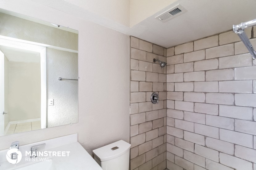a bathroom with a shower and a sink and a mirror