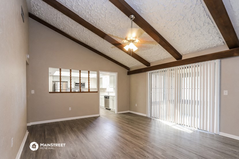 the ceilings in this spacious living room are exposed wood beams