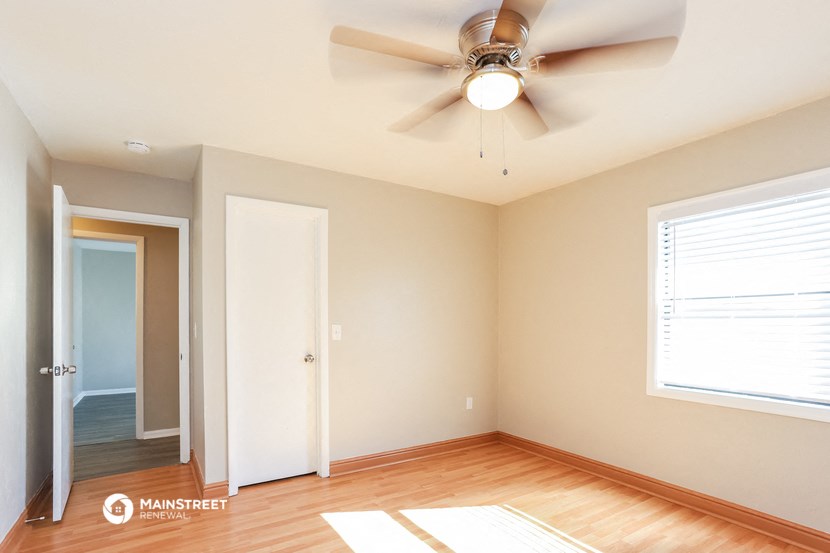 an empty room with a ceiling fan and a door to a closet