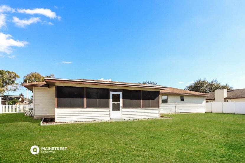 a small white house with a grassy yard in front of it