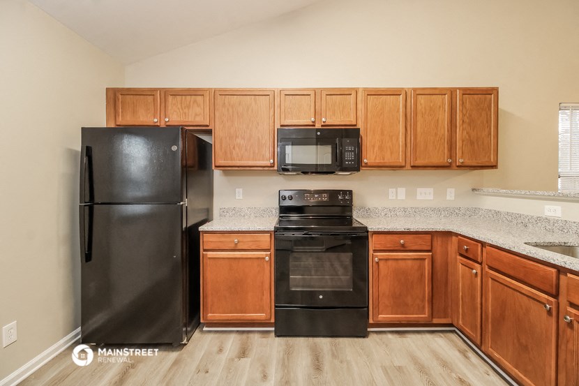 a kitchen with black appliances and wooden cabinets