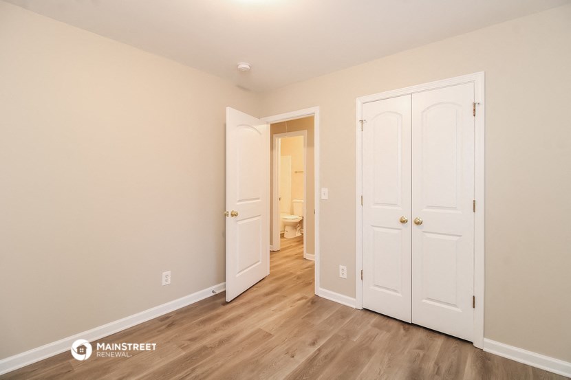 a bedroom with two closets and a door to a bathroom
