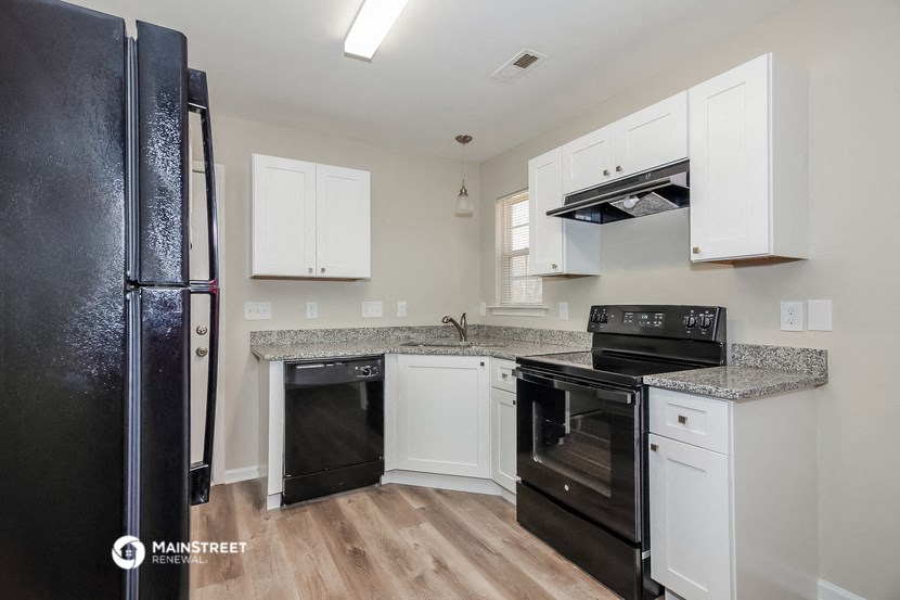 a kitchen with black appliances and white cabinets