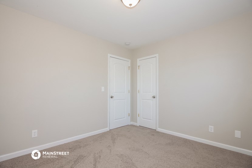 a bedroom with two doors and a carpeted floor