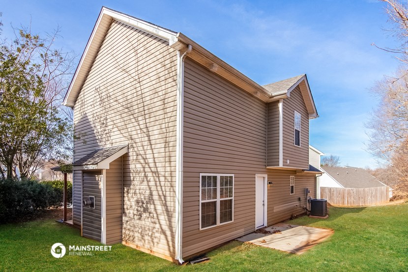 the back of a house with a garage and a yard