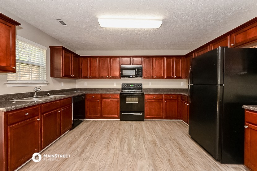 a kitchen with wooden floors and black appliances