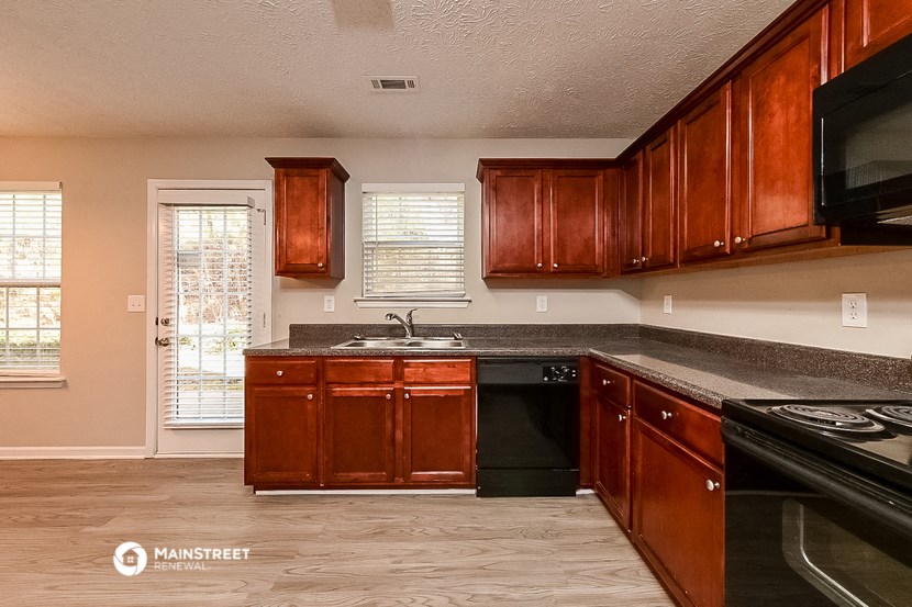 a kitchen with wooden cabinets and a black stove and a sink