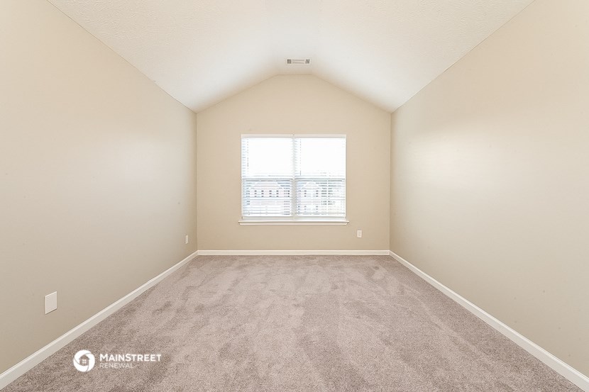 an empty room with carpet and a window