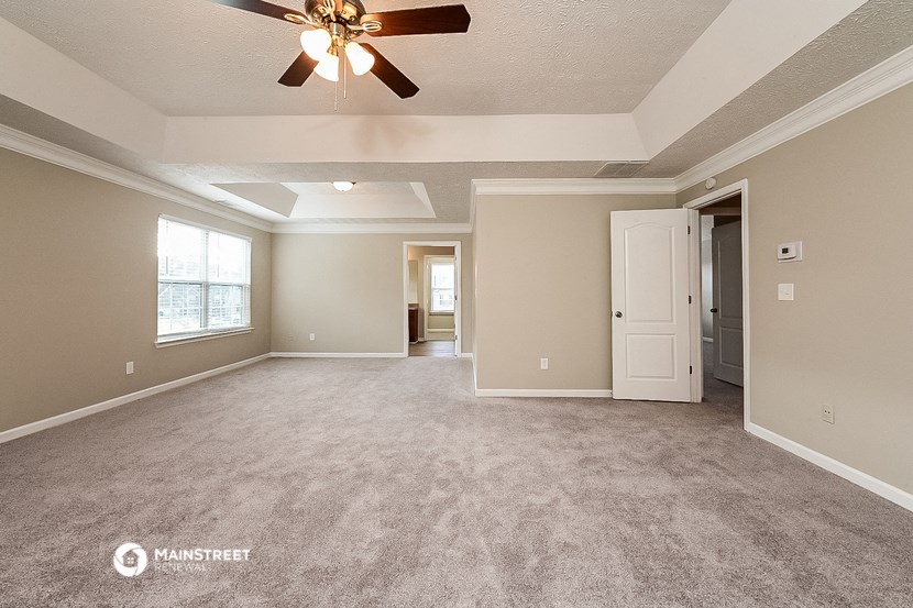 an empty living room with a ceiling fan