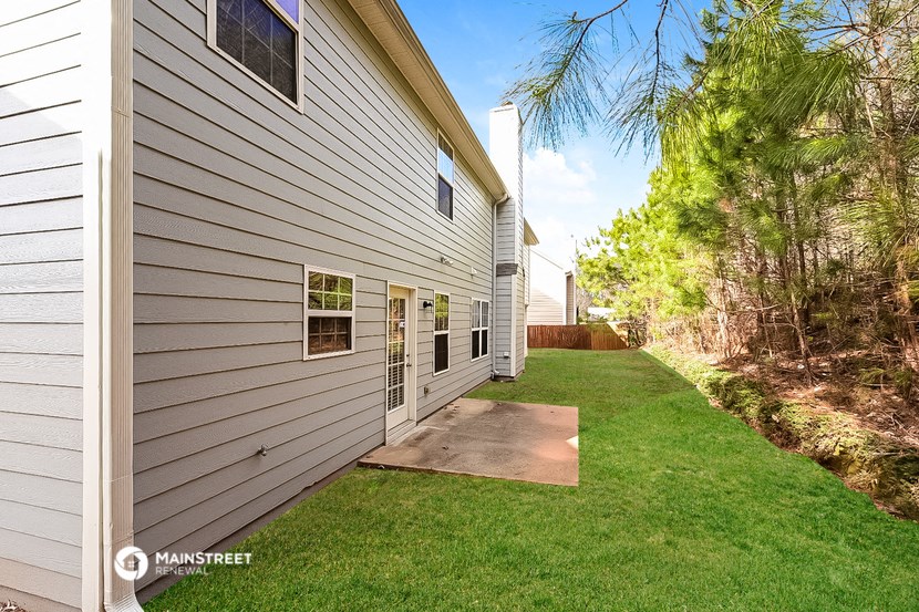 a side view of a white house with a yard and grass