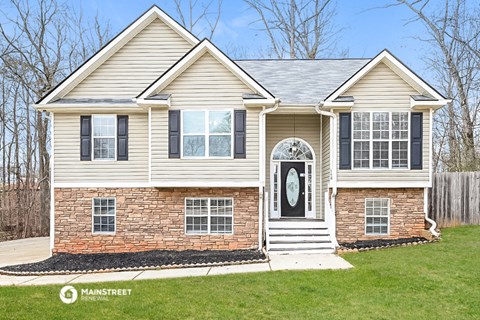 a white house with black shutters and a black front door