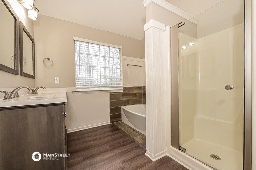 a bathroom with a tub and a sink and a shower