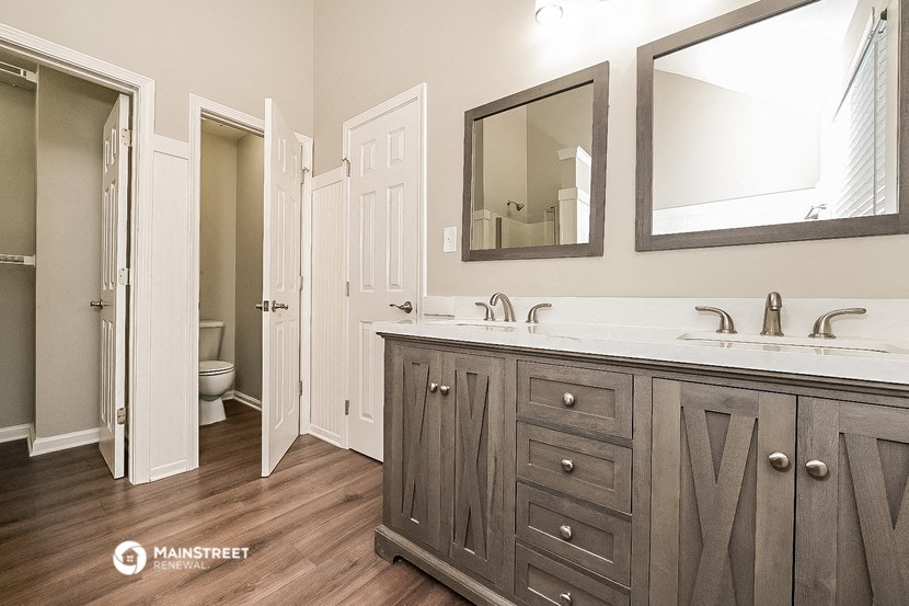 a bathroom with two sinks and two mirrors and a toilet