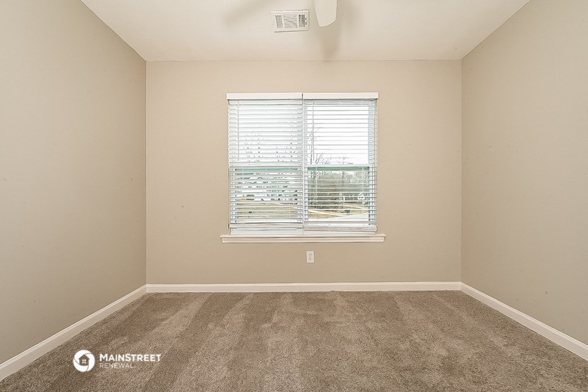 an empty room with carpet and a window