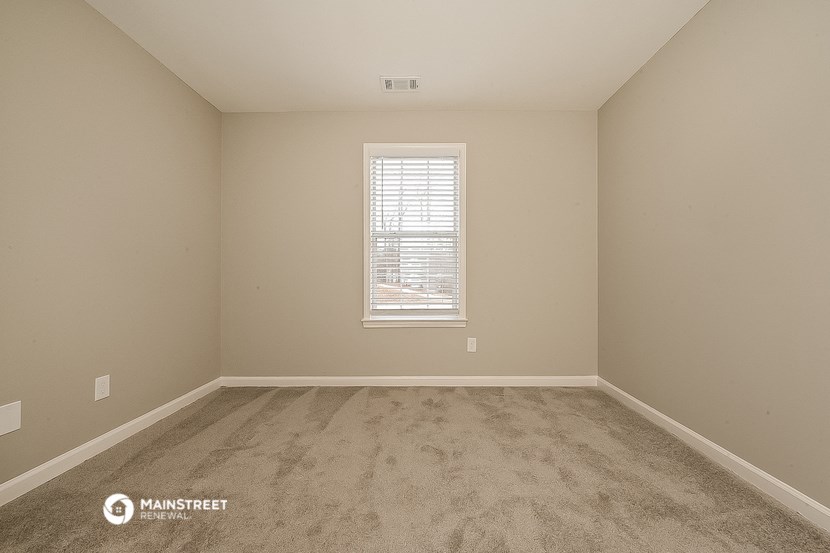 a bedroom with a carpeted floor and a window