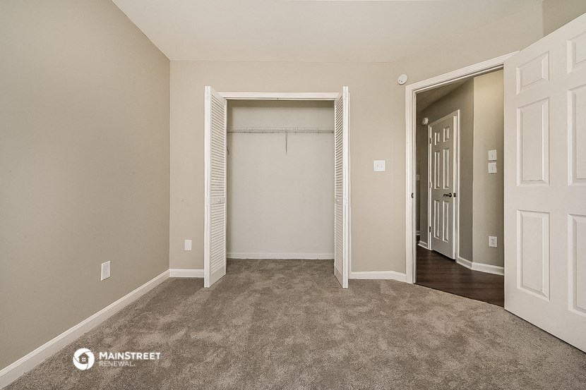 an empty bedroom with a closet and a door to a closet