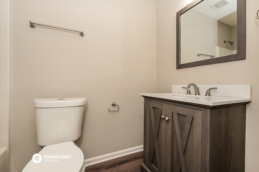 a bathroom with a toilet and a sink and a mirror