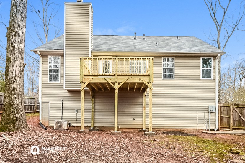 the back of a house with a deck on top of it