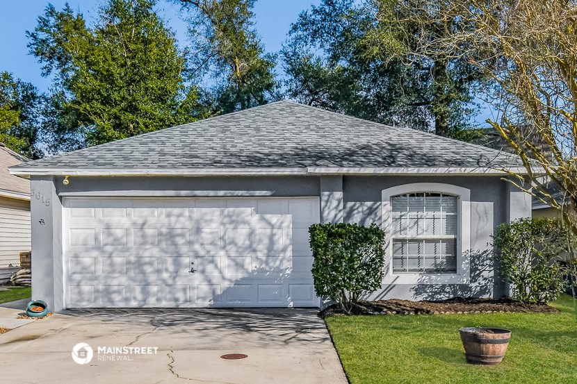 a gray house with a gray roof and a white garage door