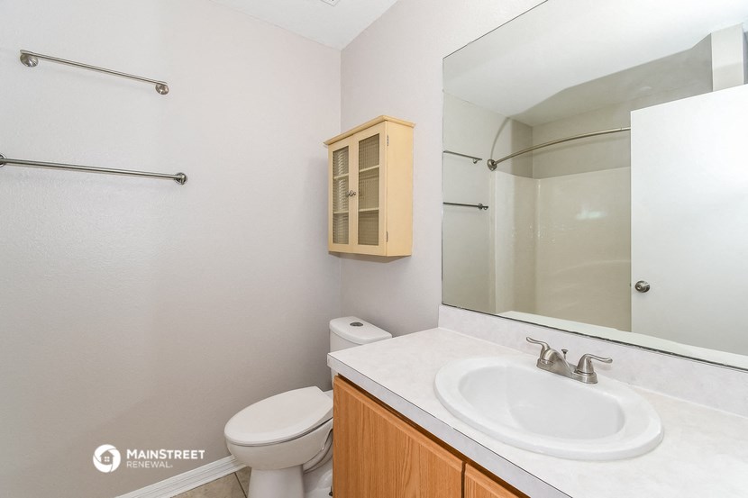 a bathroom with a sink toilet and a mirror